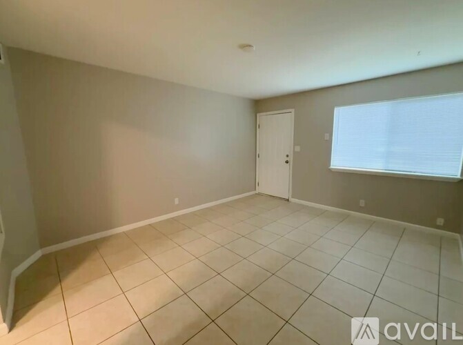 A room with a door and a window with blinds.