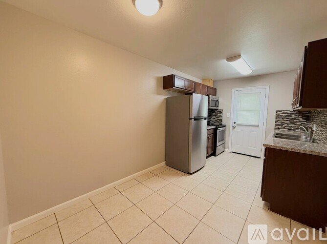 A kitchen with a refrigerator, microwave, and a countertop.