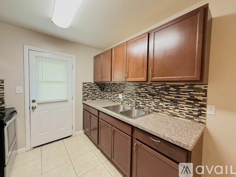 A kitchen with brown cabinets and a granite countertop.