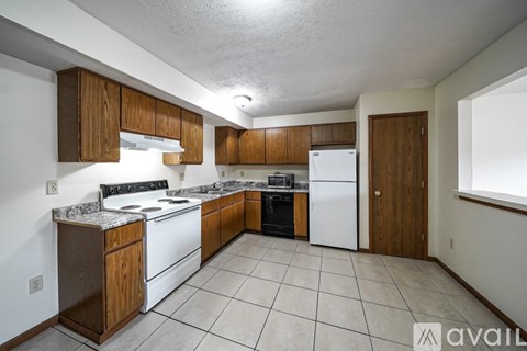 A kitchen with white appliances and wooden cabinets.