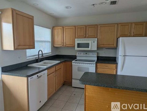 A kitchen with wooden cabinets and a white refrigerator.