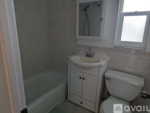A bathroom with a white sink, toilet, and bathtub.