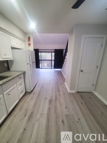 A kitchen with white cabinets and a refrigerator.