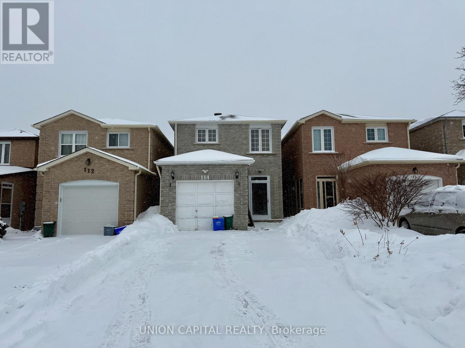 A house with snow on the roof and driveway.
