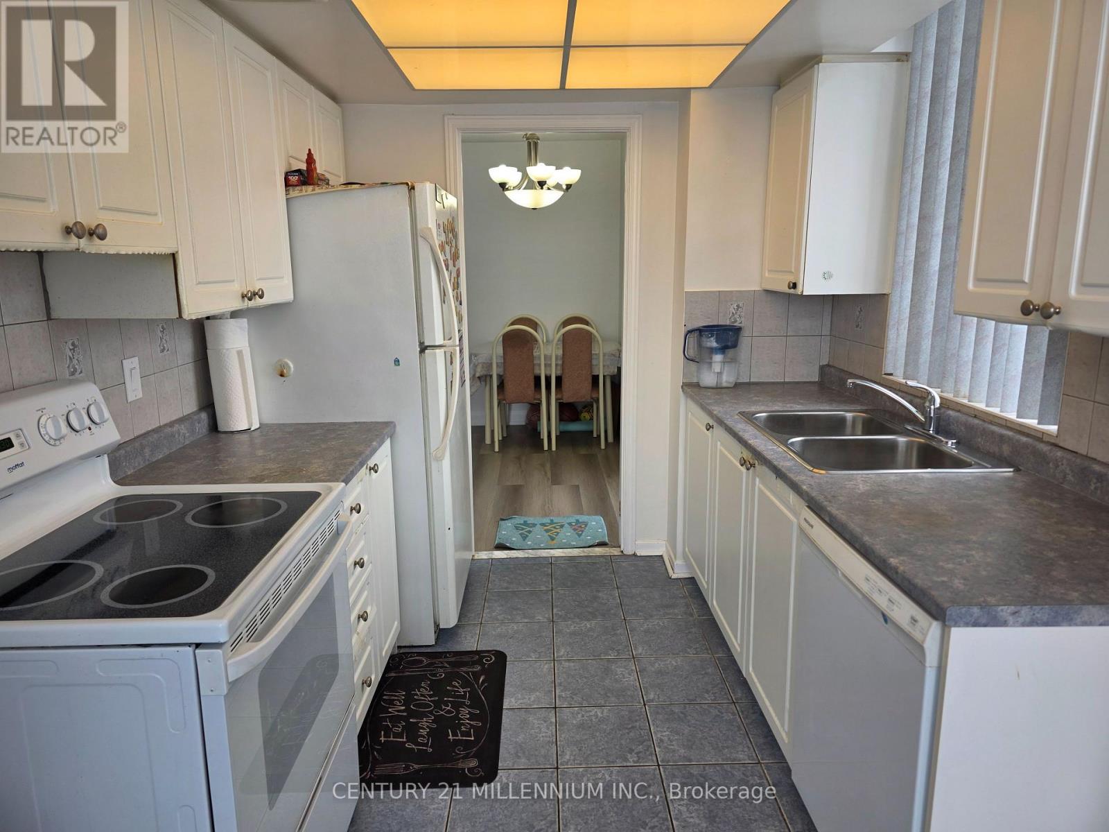 A kitchen with white appliances and a grey counter top.