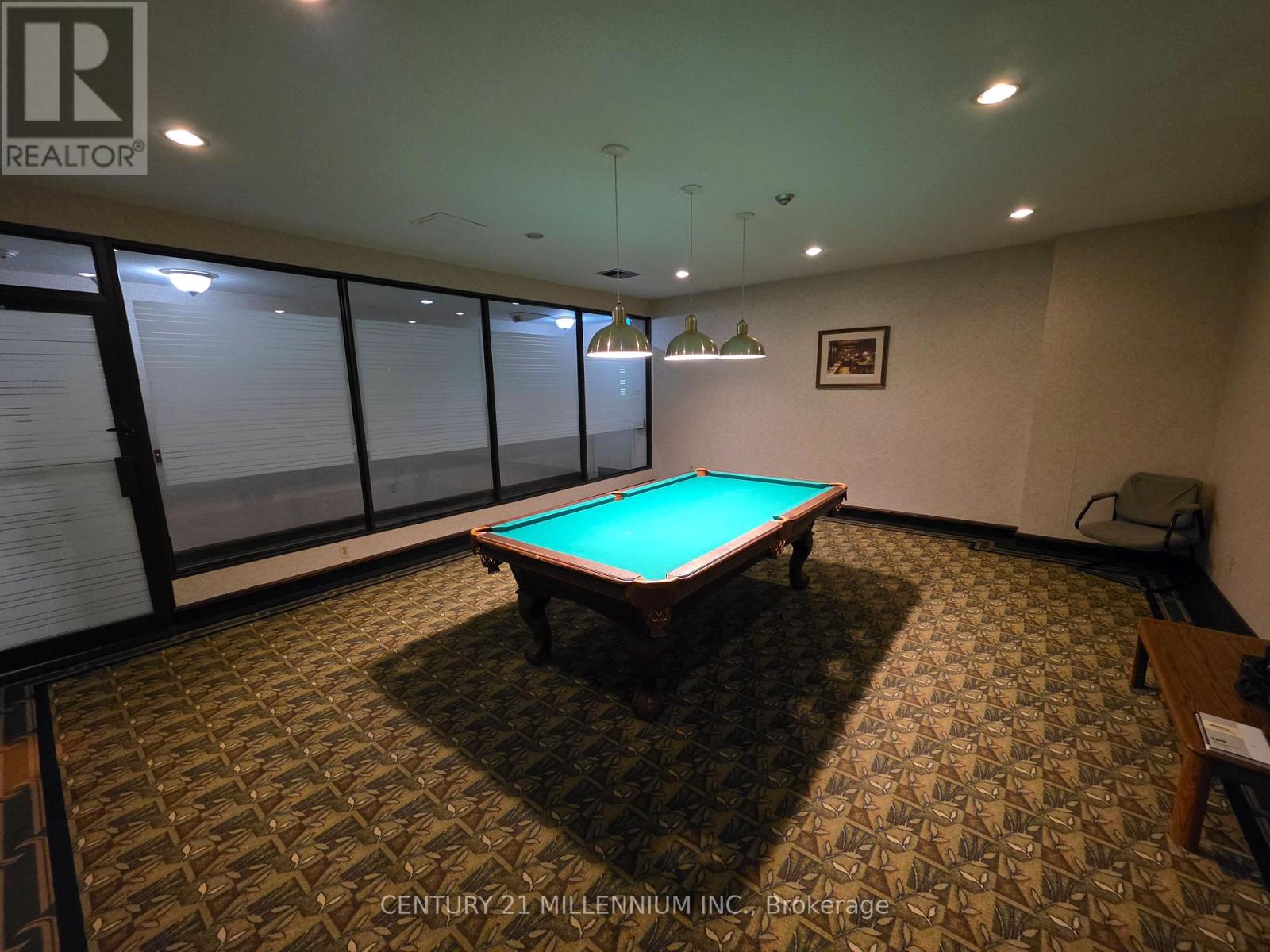 A pool table in a room with a carpeted floor.
