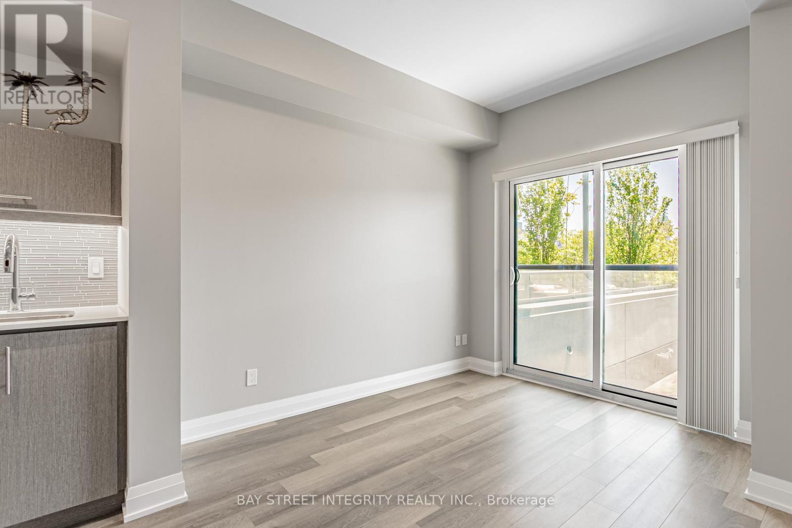 A spacious room with a sliding glass door leading to a balcony.