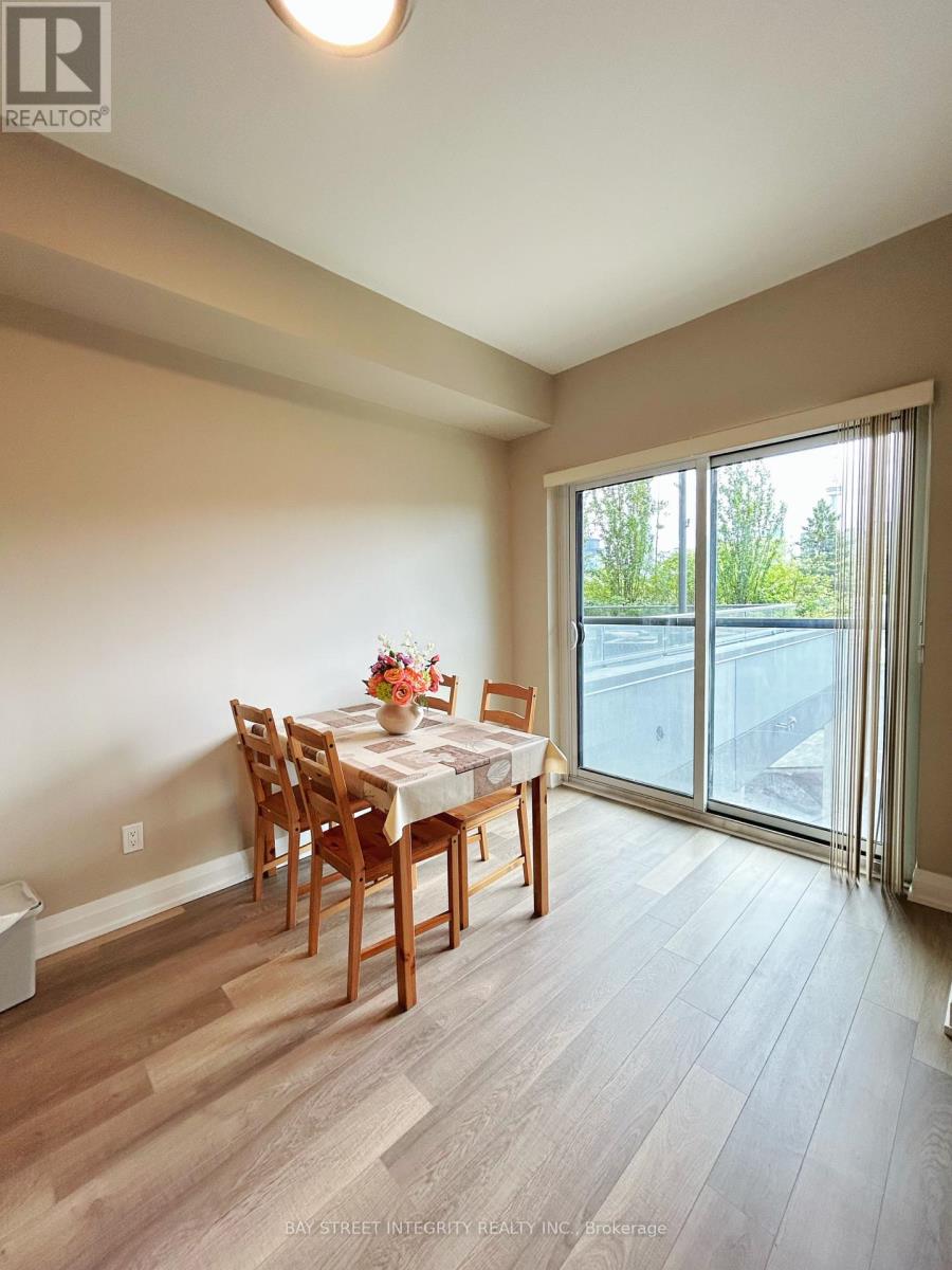 A dining room with a table set for two and a view of the backyard.