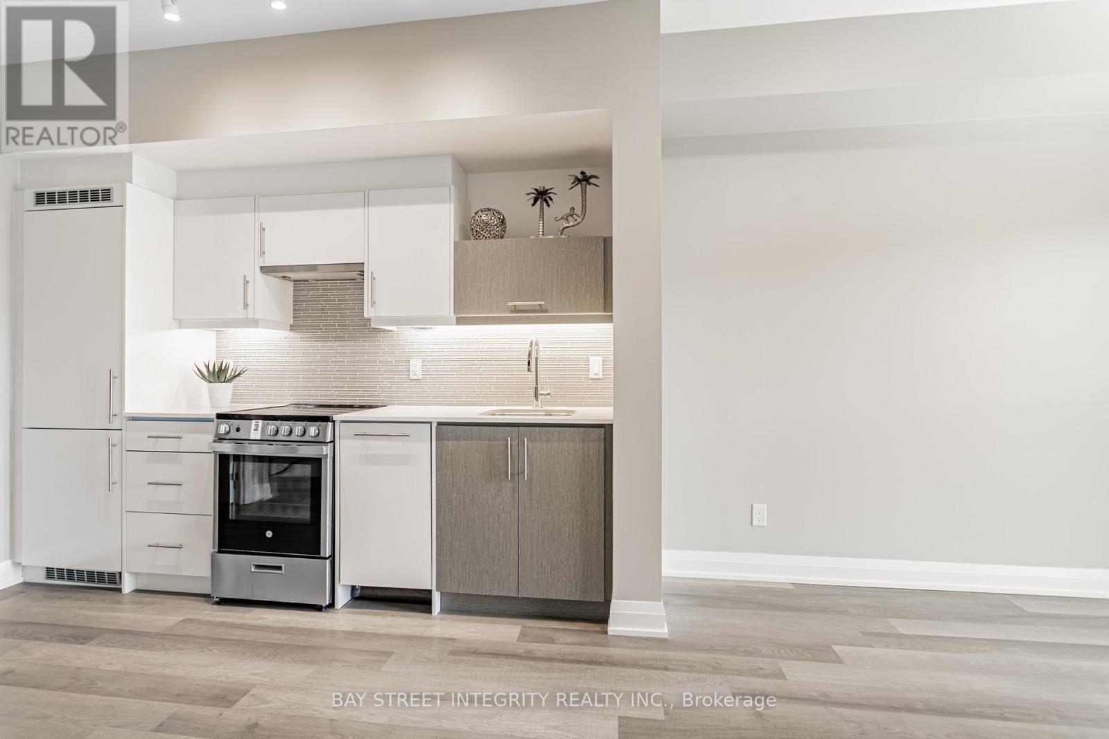 A modern kitchen with white cabinets and a stainless steel oven.