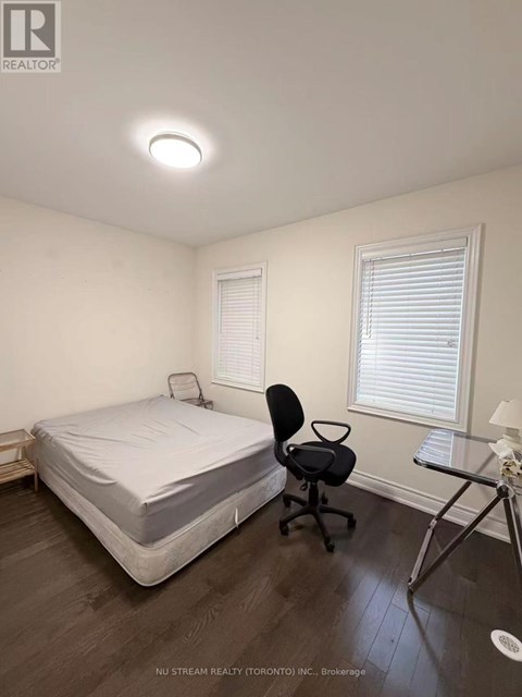 A bedroom with a bed, chair, and window.