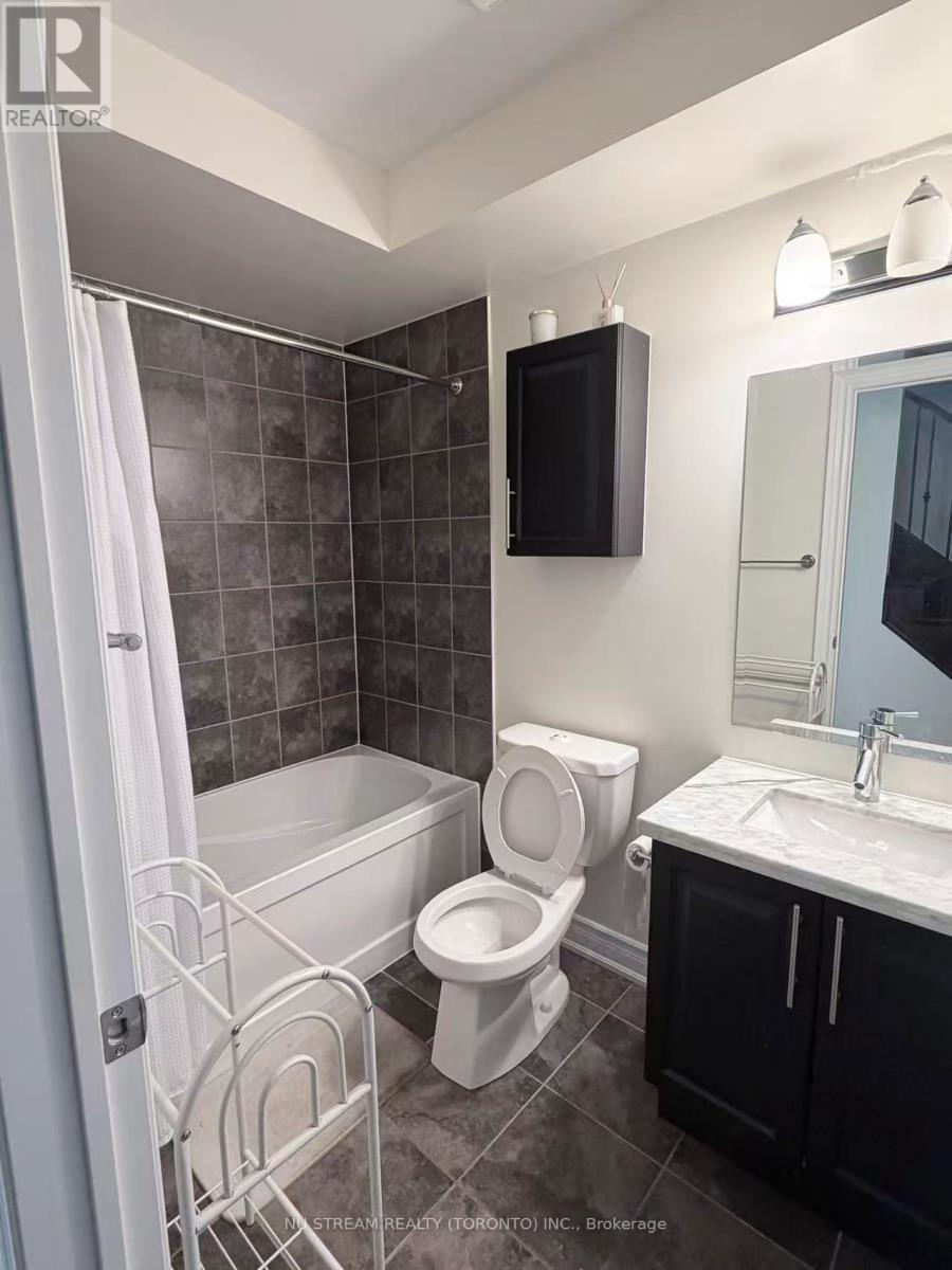 A bathroom with a toilet, sink, and bathtub.