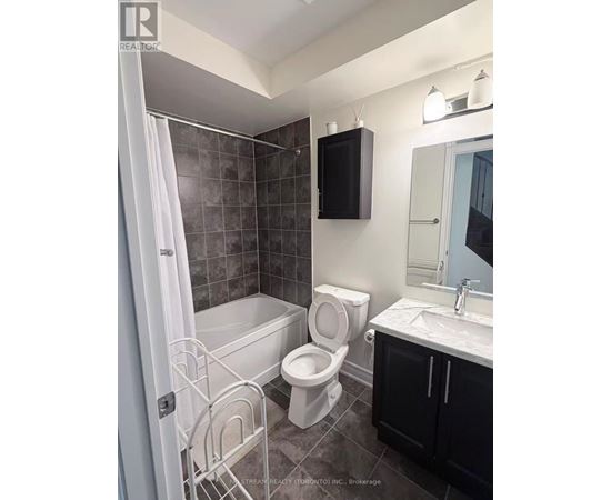 A bathroom with a toilet, sink, and bathtub.