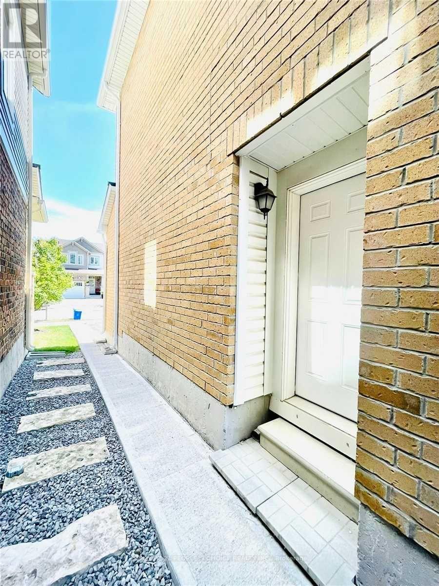 A white door is on the right side of a brick building.