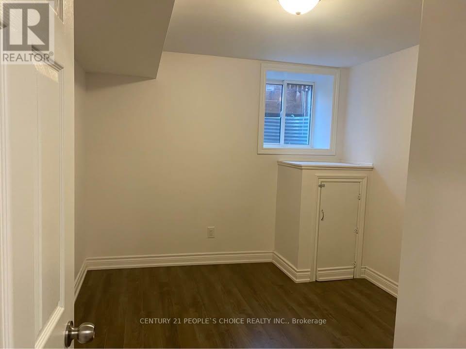 A room with a window and a wooden floor.