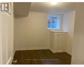 A room with a window and a wooden floor.