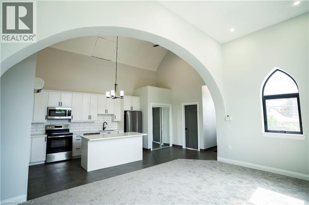 A white kitchen with a large island and a window.