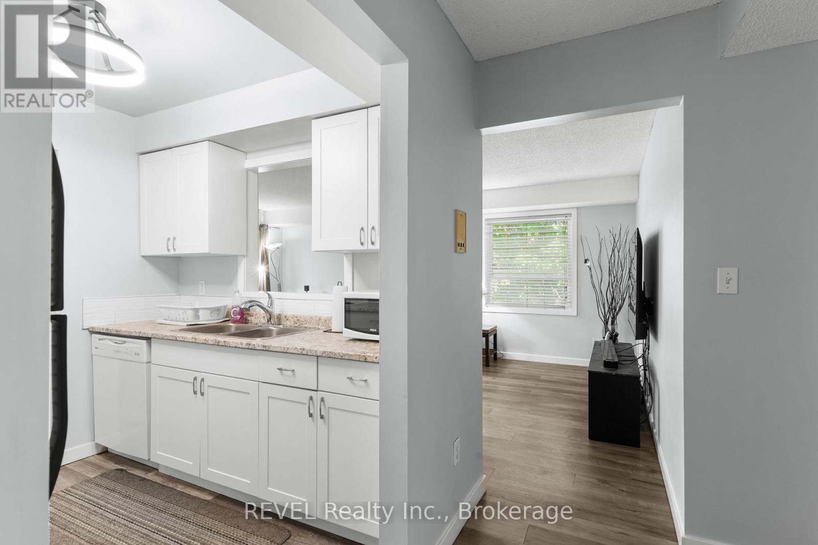 A white kitchen with a sink and a countertop.