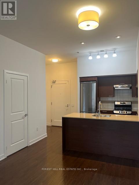 A kitchen with a sink and a stove top oven.
