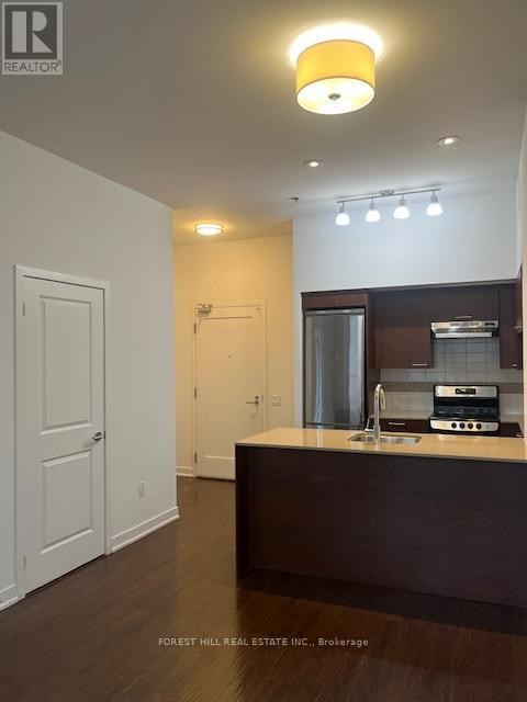 A kitchen with a sink and a stove top oven.