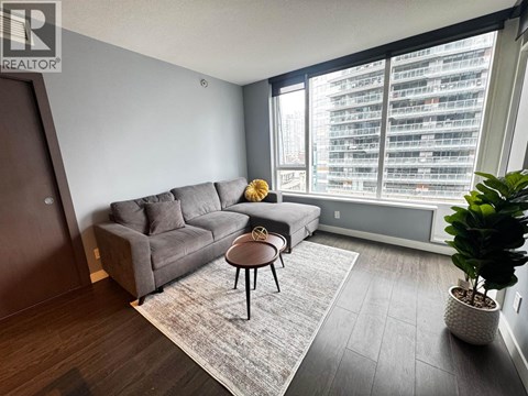 A living room with a grey couch and a small table.