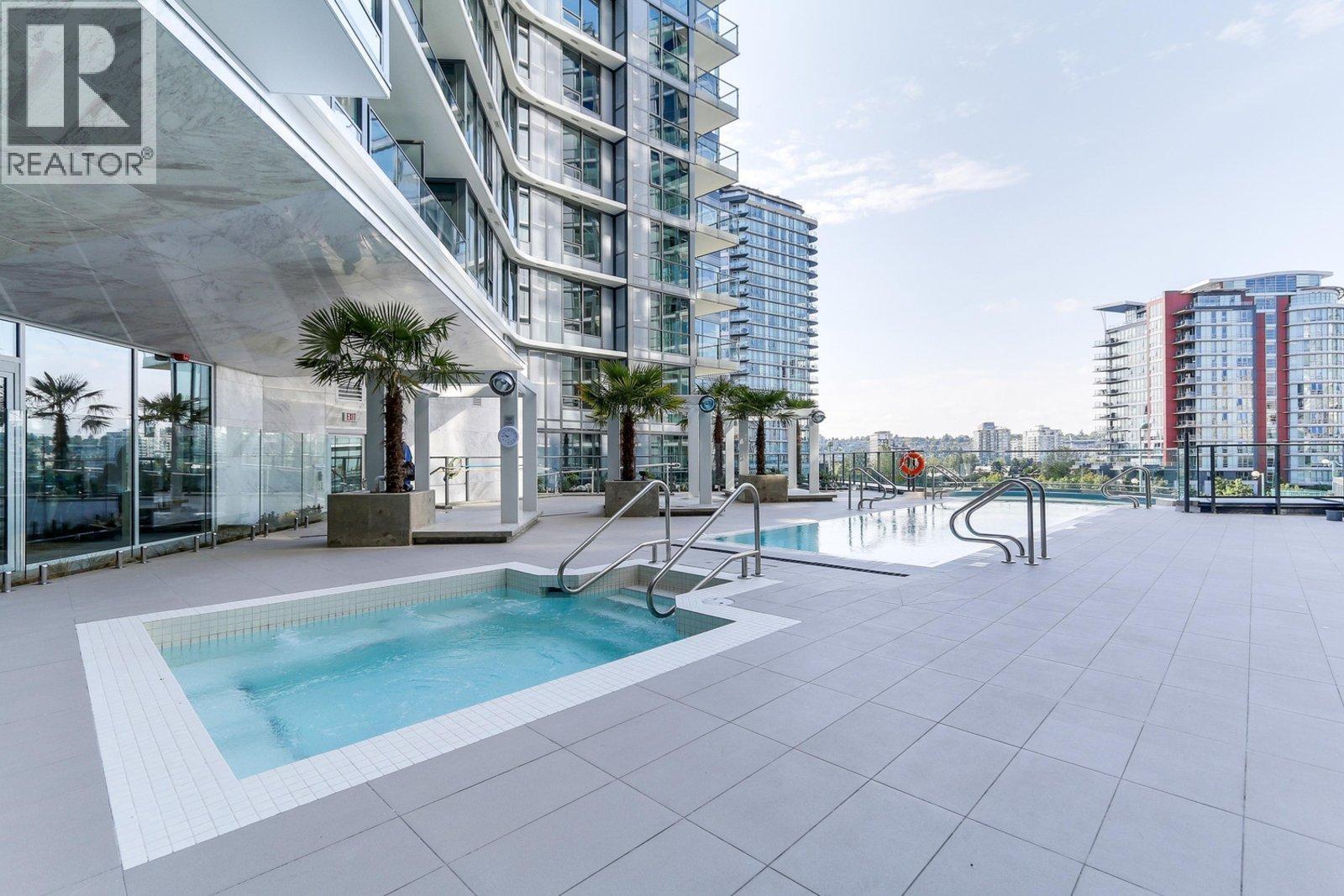 A swimming pool on a rooftop with a building in the background.