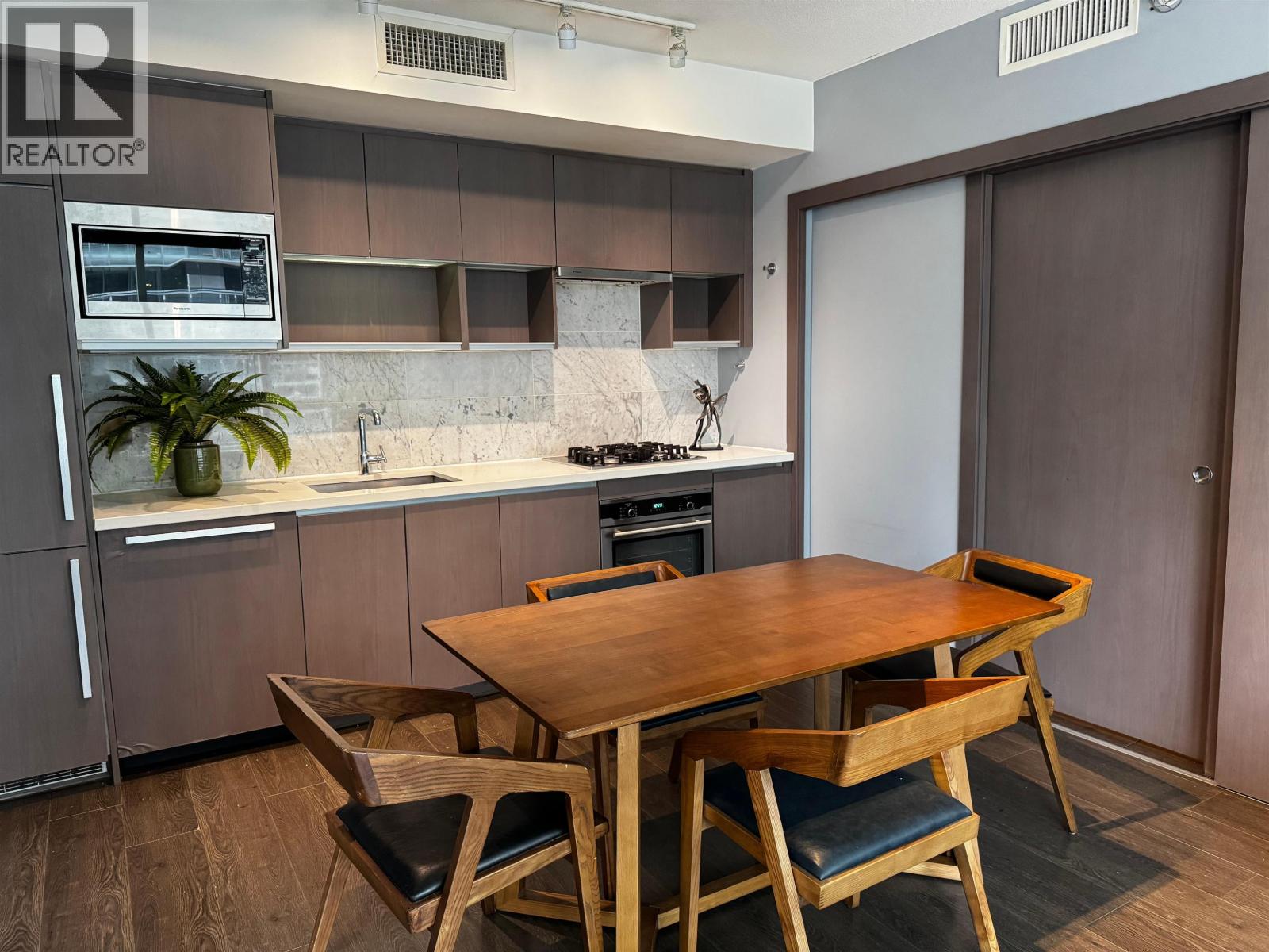 A kitchen with a table and chairs.