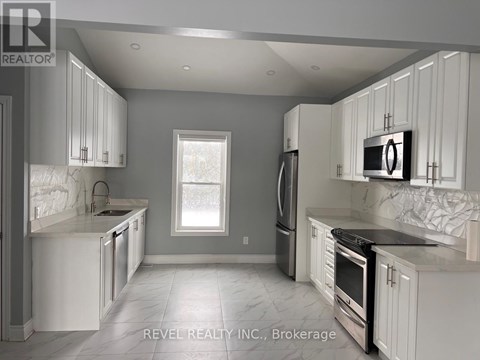 A modern kitchen with white cabinets and stainless steel appliances.