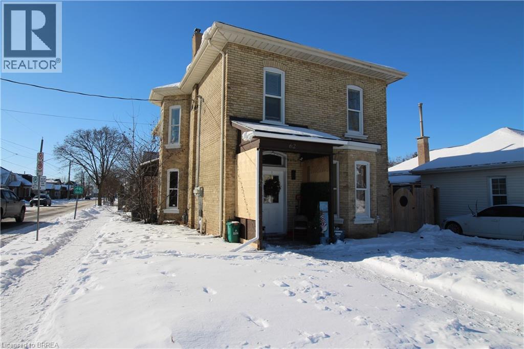 A two-story house with a snow-covered front yard.