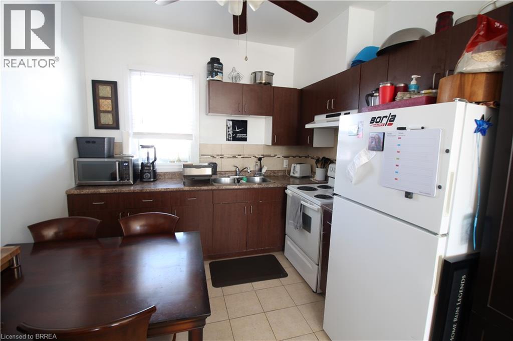 A kitchen with a white fridge and brown table.