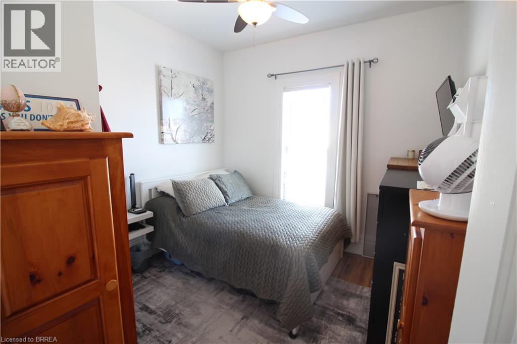 A bedroom with a bed, dresser, and window.