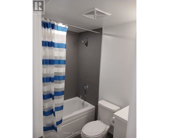 A white toilet sits next to a bathtub in a bathroom.
