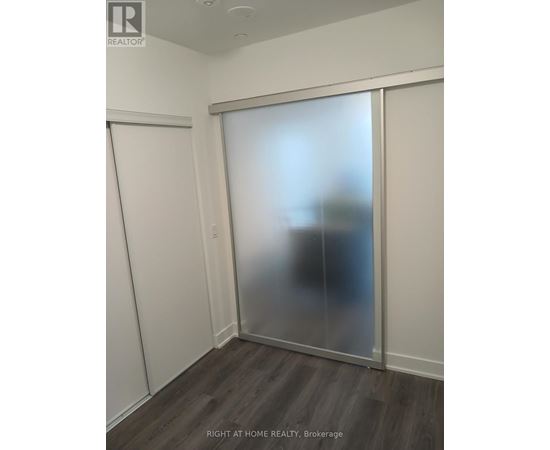A room with a sliding door and a wooden floor.