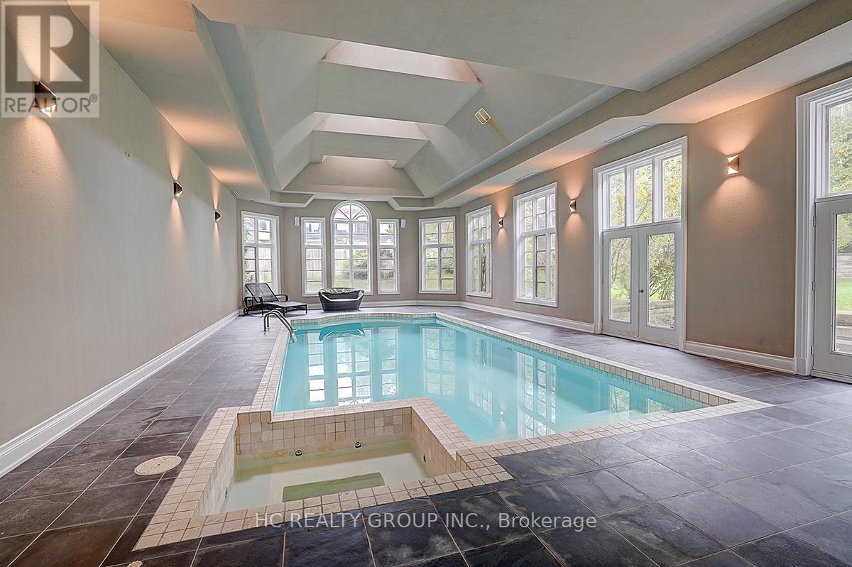 A large indoor swimming pool with a hot tub in the middle of the room.