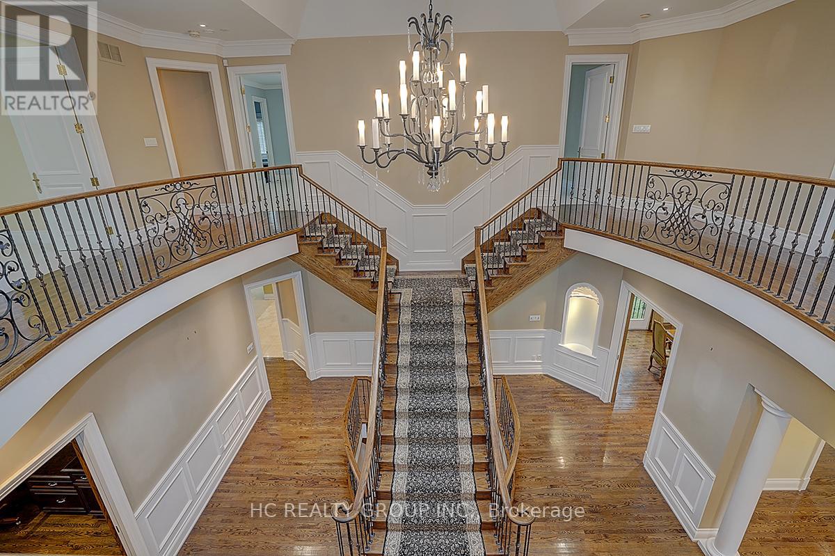 A grand staircase with a chandelier in the center of a spacious home.