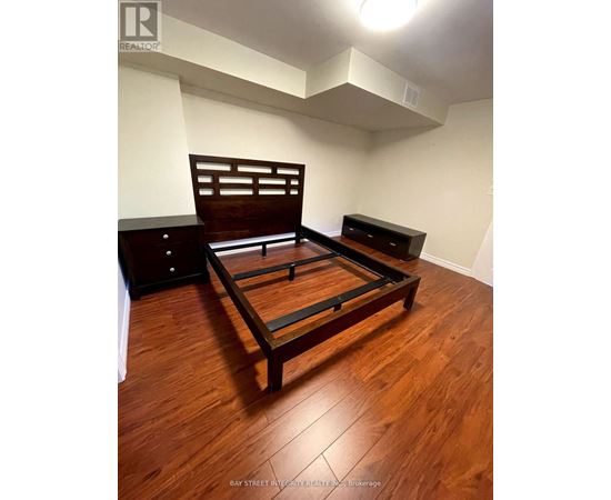 A bedroom with a bed, nightstand and dresser.