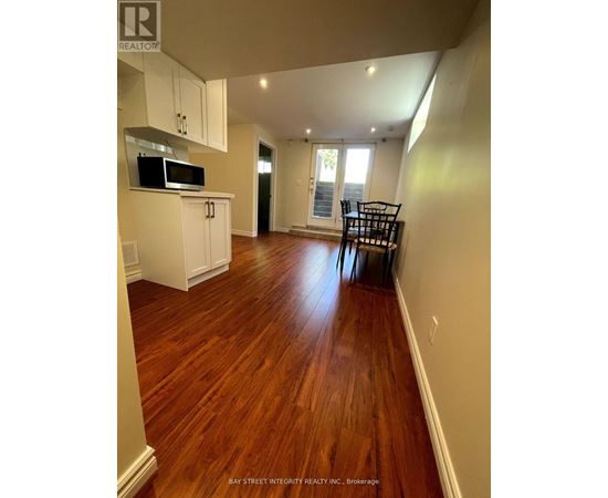 A kitchen with white cabinets and a microwave.