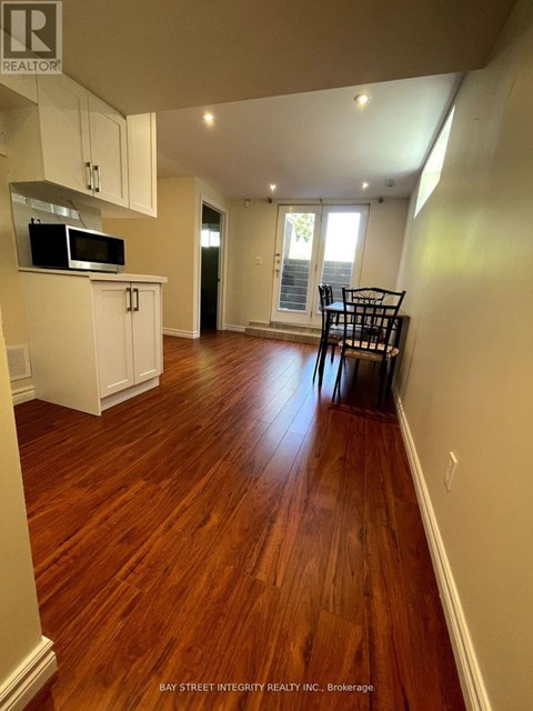 A kitchen with white cabinets and a microwave.