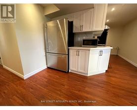 A kitchen with white cabinets and a stainless steel refrigerator.
