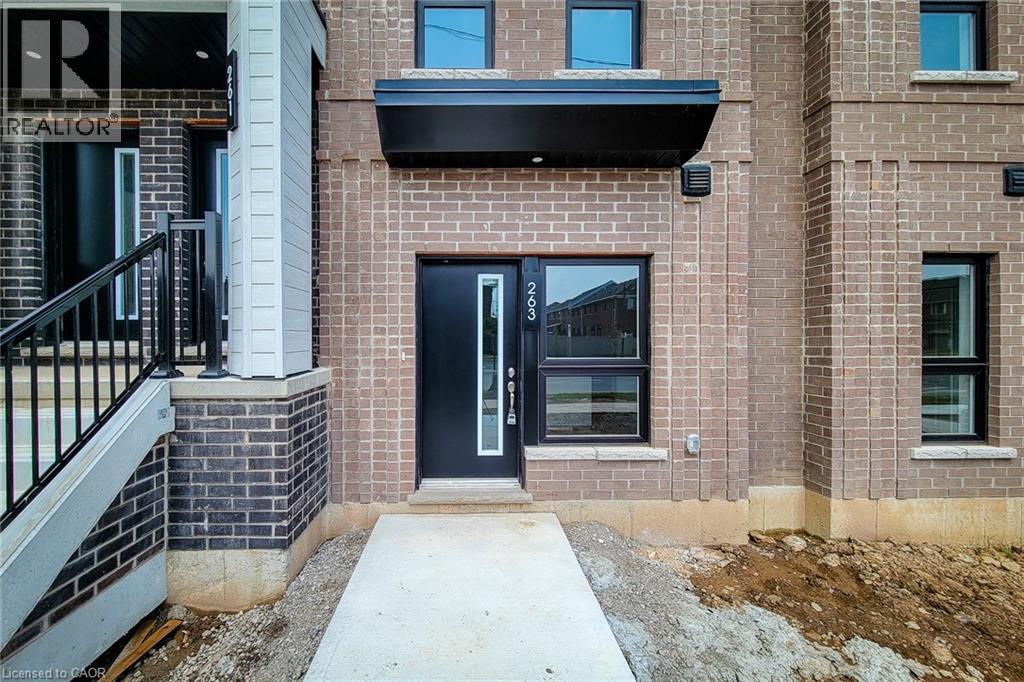 A brick building with a black awning and a glass door.