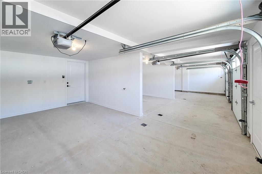 A spacious room with a white door and a ceiling light.