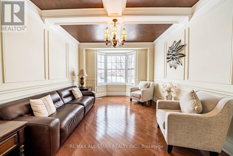 A living room with a brown leather couch and a chandelier.