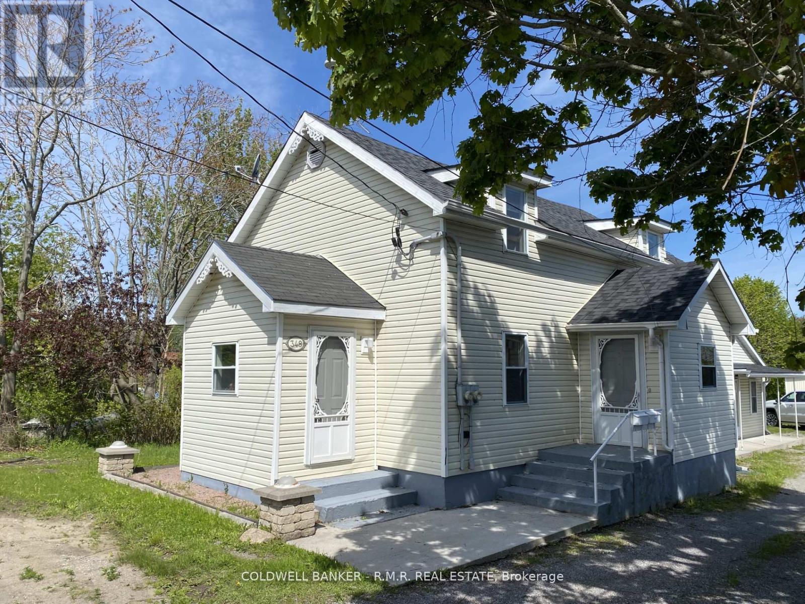 A two-story house with a front porch and a garage door.