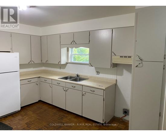 A kitchen with white cabinets and a white fridge.