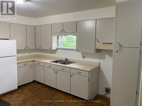 A kitchen with white cabinets and a white fridge.