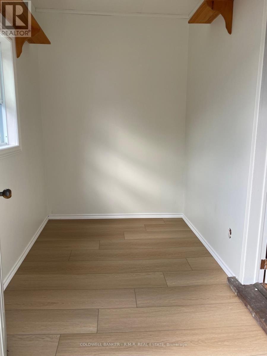 A room with wooden flooring and white walls.