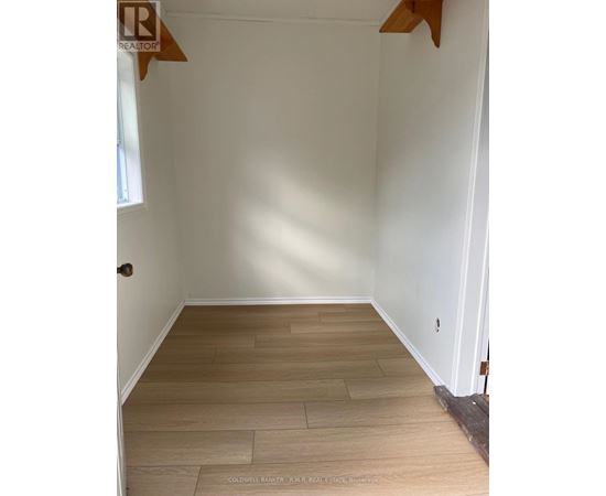 A room with wooden flooring and white walls.