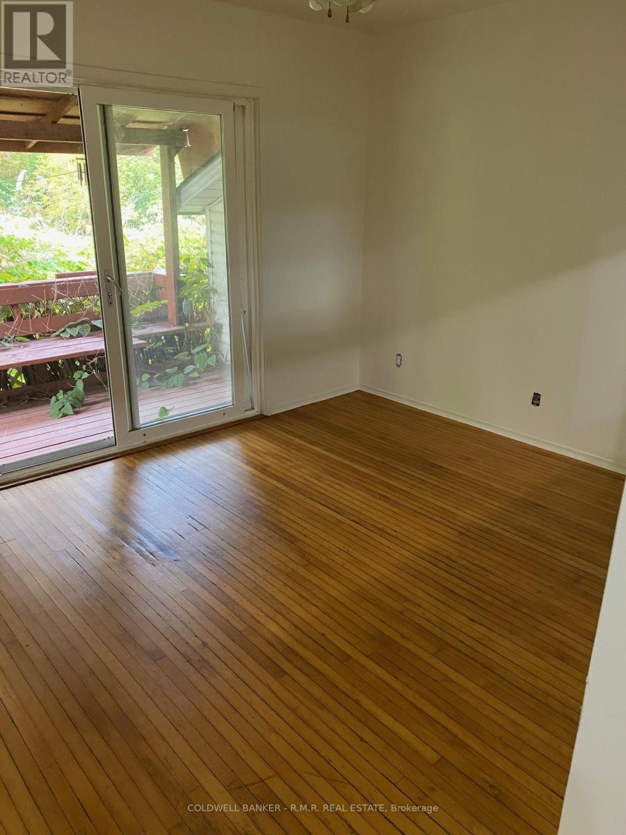 A room with wooden flooring and a door leading outside.