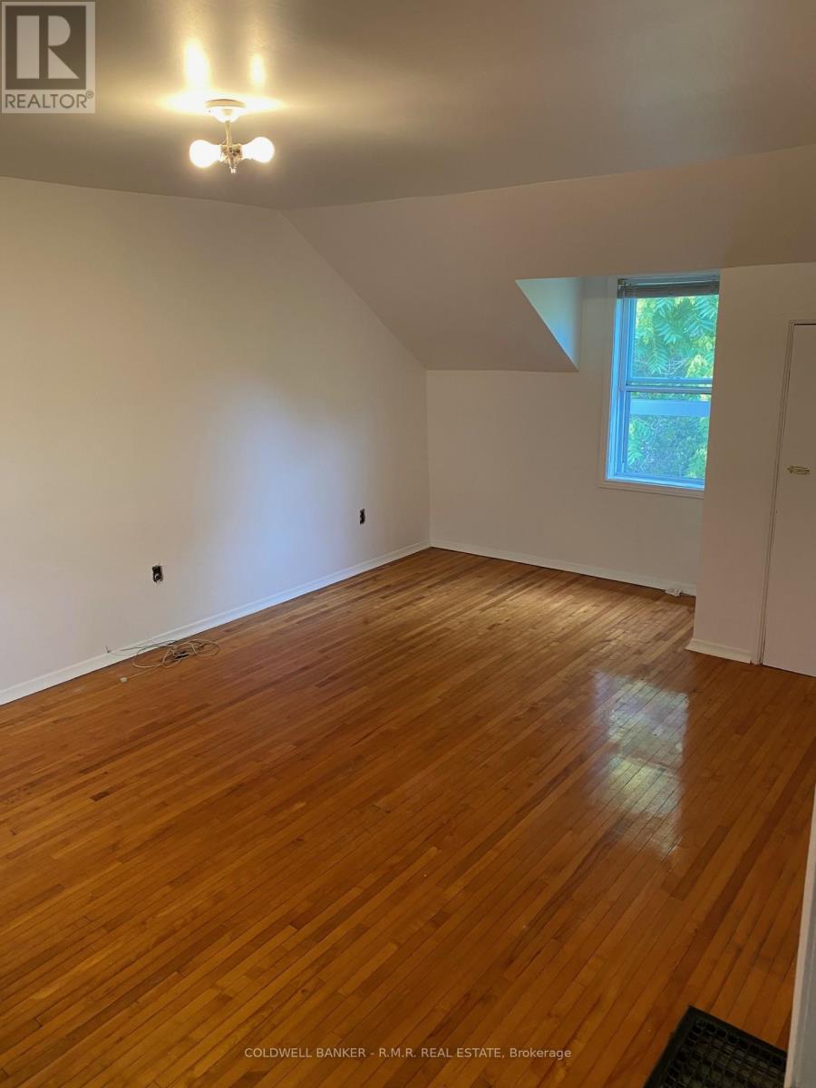 A room with wooden flooring and a window letting in natural light.