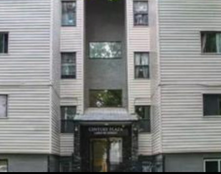 A building with a black awning and a glass window.