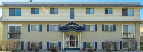 A two-story building with a black awning and a sign that reads "Apartments".